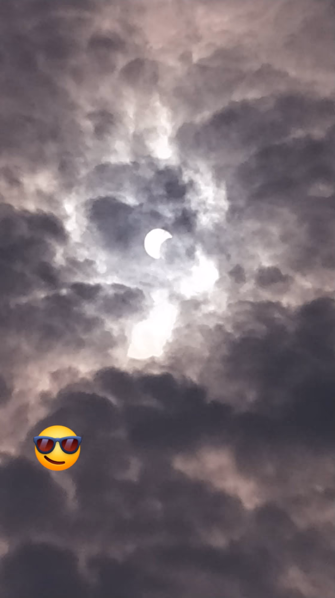 Partial solar eclipse seen through cloud